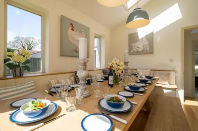 a dining room table with blue and white dishes on it at Winton Lodge in Aldeburgh