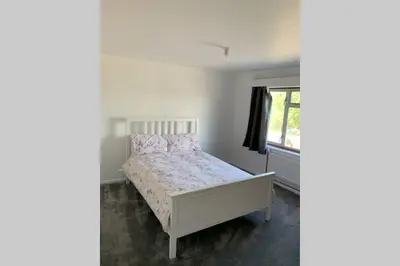 a bedroom with a bed and a window at 5 Bedroom House with outdoor space in Upminster