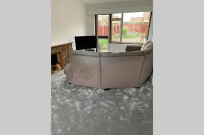 a living room with a couch and a television at 5 Bedroom House with outdoor space in Upminster
