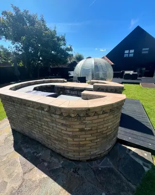 a stone fire pit in a yard with a domedificialificialificialificialificial at The Kings Head in Chelmsford
