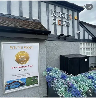 a sign on the side of a building with flowers at The Kings Head in Chelmsford