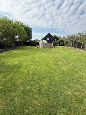 a large grassy yard with a house in the background at The Kings Head in Chelmsford