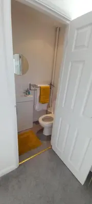 a bathroom with a toilet and a yellow towel at Barn Farm Guest House in Cold Norton