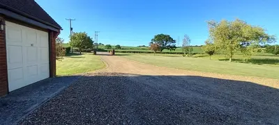 a driveway leading to a house with a garage at Barn Farm Guest House in Cold Norton