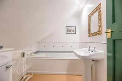 a bathroom with a bath tub and a sink at The Spinney Saxtead nr Framlingham in Woodbridge