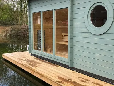 a house on a dock on a body of water at Little Oaks in Stowmarket