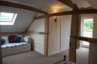 a room with a couch in the corner of a room at Little Oaks in Stowmarket