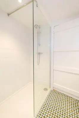 a shower with a glass door in a bathroom at Theberton Cottage in Theberton