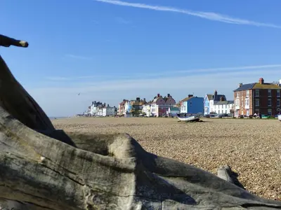 a view of a beach with houses in the background at Longshore, Aldeburgh in Aldeburgh