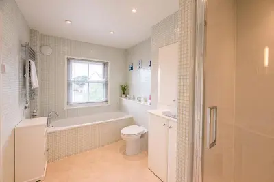 a bathroom with a tub and a toilet and a sink at Longshore, Aldeburgh in Aldeburgh