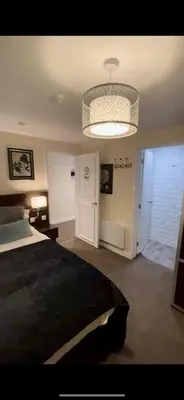 a bedroom with a large bed and a chandelier at The High Flyer in Ely