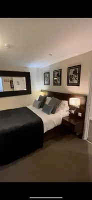 a bedroom with a large bed and a table with a lamp at The High Flyer in Ely