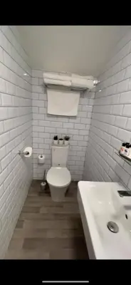 a white bathroom with a toilet and a sink at The High Flyer in Ely