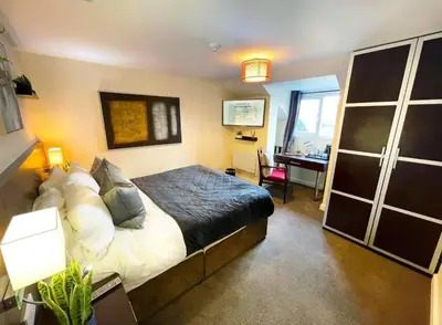 a bedroom with a bed and a desk in it at The High Flyer in Ely