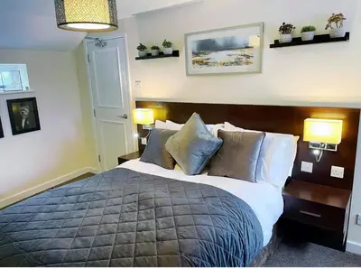 a bedroom with a large bed and two lamps at The High Flyer in Ely