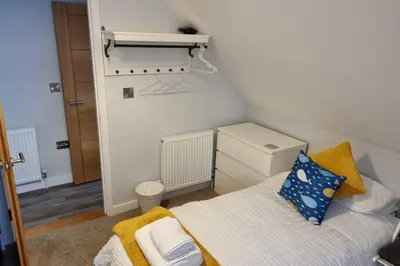 a small bedroom with a bed and a desk at 2 Bedroom Seafront Apartment in Felixstowe