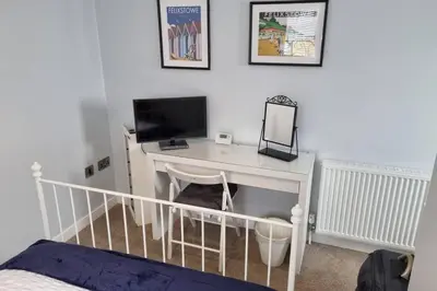 a bedroom with a desk with a computer on it at 2 Bedroom Seafront Apartment in Felixstowe