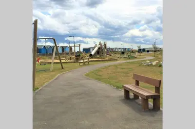 a park with a bench and a playground at 2 Bedroom Seafront Apartment in Felixstowe