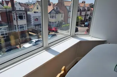 a bedroom with two windows with a view of a street at 2 Bedroom Seafront Apartment in Felixstowe