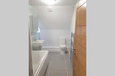 a bathroom with a tub and a toilet and a sink at 2 Bedroom Seafront Apartment in Felixstowe