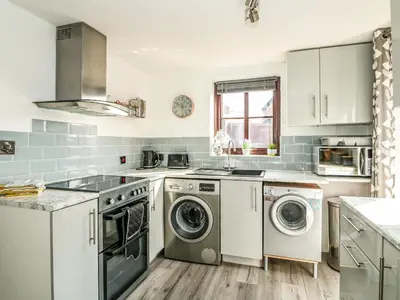 a kitchen with a washer and dryer at Chalk Cottage in Thetford