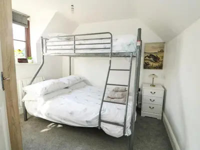 a bunk bed with a ladder in a room at Chalk Cottage in Thetford