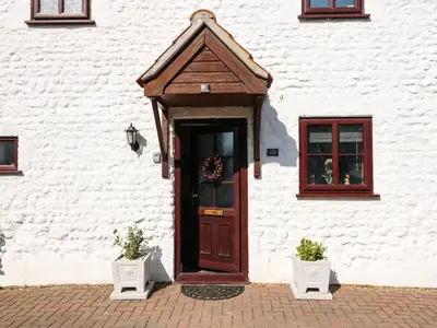 a door of a white building with a wreath on it at Chalk Cottage in Thetford
