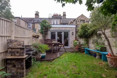 a backyard with a table and a fence at Lovely Central Cambridge Home in Cambridge