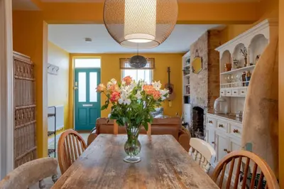 a vase of flowers on a wooden table in a kitchen at Lovely Central Cambridge Home in Cambridge
