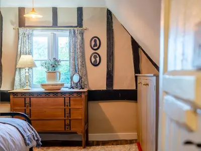 a bedroom with a bed and a dresser with a window at Little Crown in Winfarthing