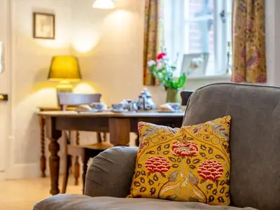 a chair with a pillow on it with a table at Little Crown in Winfarthing