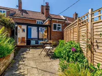a patio with a table and a fence at Angel Lane in Woodbridge