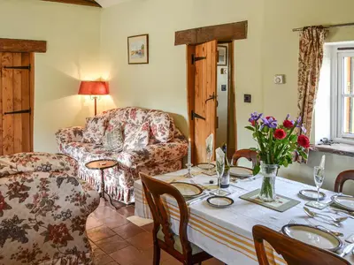 a living room with a table and a couch at Bradcar Farm Cottage in Snetterton