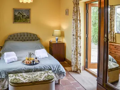 a bedroom with a bed with a tray of fruit on it at Bradcar Farm Cottage in Snetterton