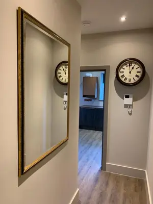 a mirror and two clocks on a wall at Oddfellows Hall in Thetford