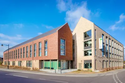 a brick building on the side of a street at Holiday Inn Express Cambridge West - Cambourne by IHG in Cambridge