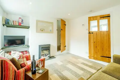 a living room with a couch and a fireplace at Poppy Cottage, Aldeburgh - Prime location, close to the beach and High Street - Aldeburgh Coastal Cottages in Aldeburgh