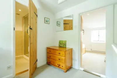 a bathroom with a wooden dresser and a mirror at Poppy Cottage, Aldeburgh - Prime location, close to the beach and High Street - Aldeburgh Coastal Cottages in Aldeburgh