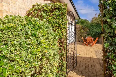 an entrance to a garden with an iron gate at Maltings Lodge in Chelsworth