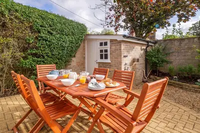 a wooden table with chairs and food on it at Maltings Lodge in Chelsworth