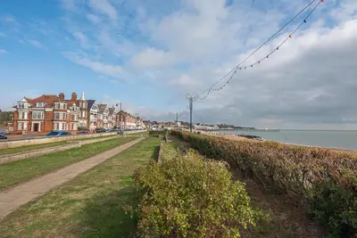 a path next to a beach with buildings and the ocean at 4 Buregate House, Felixstowe in Felixstowe