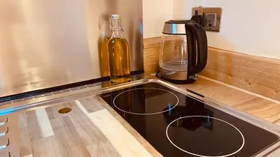 a kitchen counter with a sink and a bottle on it at Private Detached Annex in Isleham Village in Isleham