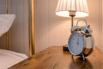 an alarm clock sitting on a table next to a lamp at North Cottage, Alderton in Woodbridge