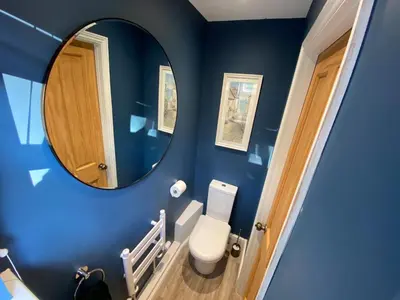a blue bathroom with a toilet and a mirror at Refurbished Victorian Villa- Free Parking- Sleeps6 in Bury Saint Edmunds