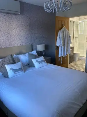 a bedroom with a large white bed with blue pillows at The Oaks, Luxury 2 bedroom cottage in a peaceful location in Haughley