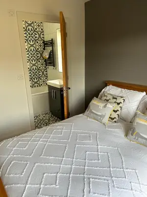 a bedroom with a bed and a bathroom with a mirror at The Oaks, Luxury 2 bedroom cottage in a peaceful location in Haughley