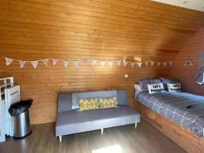 a room with two beds and a couch in it at Wildflower Meadow Cabins in Whitington