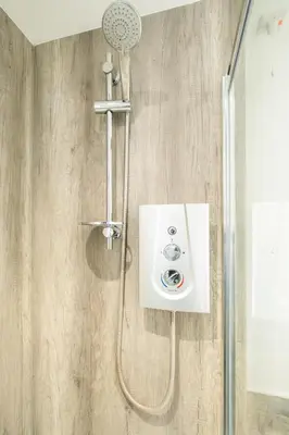a shower with a shower head in a bathroom at The Britten - Aldeburgh Coastal Cottages in Aldeburgh