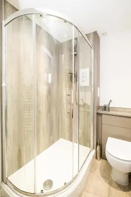 a bathroom with a shower and a toilet at The Britten - Aldeburgh Coastal Cottages in Aldeburgh
