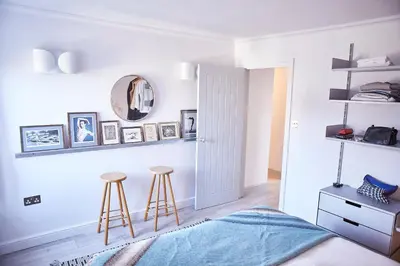 a bedroom with a bed and two stools at SEALOFT, Aldeburgh , Stay in Suffolk in Aldeburgh